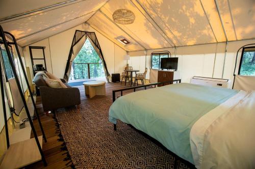 a bedroom with a large bed in a tent at Stunning Tented Cabin with Fire Pit in Des Moines, Iowa in Marquisville