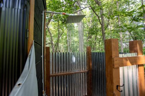 an open door of a wooden fence with a broom at Stunning Tented Cabin with Fire Pit in Des Moines, Iowa in Marquisville