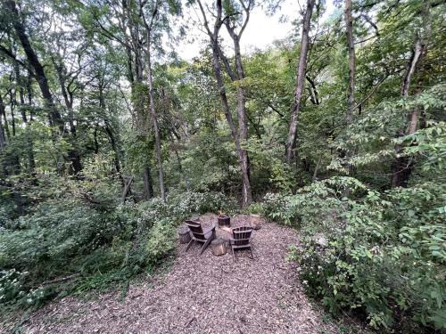 a picnic table and chairs in the woods at Stunning Tented Cabin with Fire Pit in Des Moines, Iowa in Marquisville