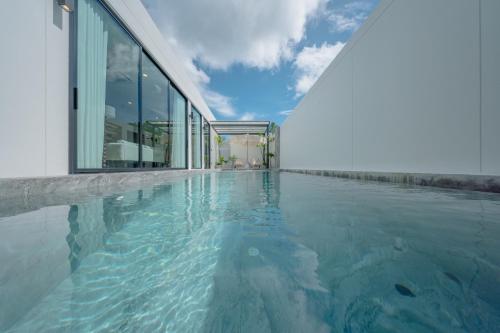 a swimming pool in front of a building at New 3BR Pool Villa w Jacuzzi Ao Nang Krabi in Ban Khlong Haeng