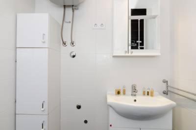 ein weißes Badezimmer mit einem Waschbecken und einem Spiegel in der Unterkunft Apartment Sara in Dubrovnik