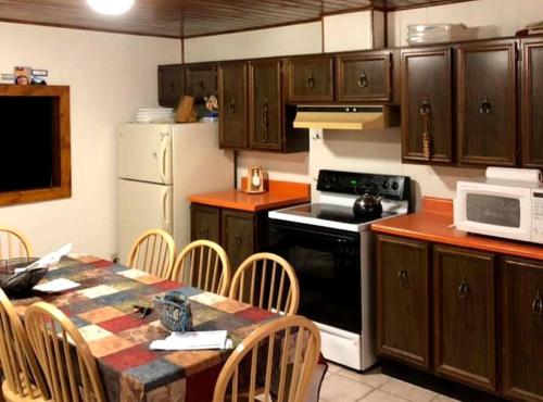 une cuisine avec une table et un réfrigérateur blanc dans l'établissement Spacious Cottage Rental with a Fire Pit and Fabulous Views in Summit Lake, Wisconsin, à Summit Lake