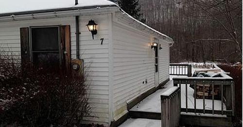 a small white building with a door and a porch at Spacious Cabin Rental next to Balsam Mountain in Upstate New York in Big Indian