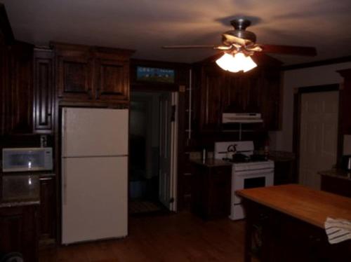a kitchen with a white refrigerator and a ceiling fan at Historic Cabin Rental with Mountain Views in Potter County, Pennsylvania in Short Run