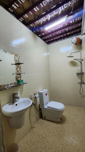 a bathroom with a toilet and a sink at Bait Aljabal Hospitality Inn in Al Ḩamrāʼ