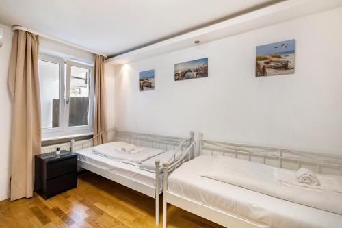 two beds in a room with a window at Appart - Aldars 6 Munich in Munich