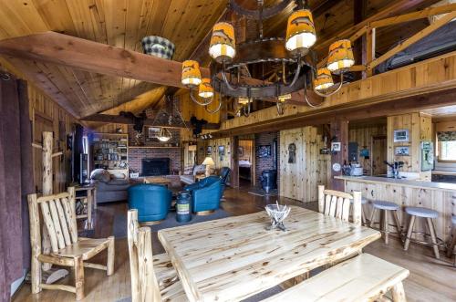 a kitchen and living room with a wooden table and chairs at Scenic Cabin with Wildlife Views Near Madison River, Ennis, Montana in Ennis