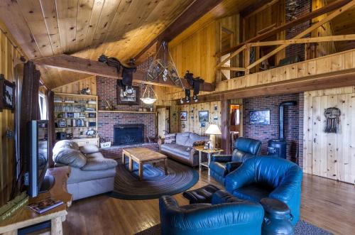 a living room with leather furniture and a brick wall at Scenic Cabin with Wildlife Views Near Madison River, Ennis, Montana in Ennis