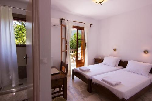 a bedroom with two beds and a window at Naftilos Skiathos in Skiathos