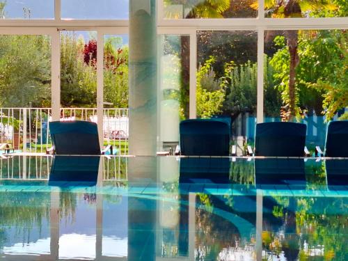a pool with chairs in front of a building at Seegarten in Caldaro
