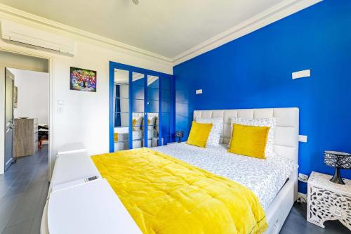 a blue bedroom with a large bed with yellow pillows at Apartment with pool and garden in Taradeau