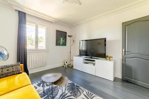 a living room with a television and a couch at Apartment with pool and garden in Taradeau