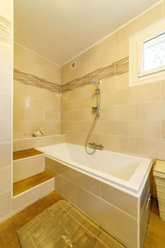 a bathroom with a bath tub and a window at Apartment with pool and garden in Taradeau