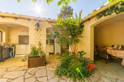 an outdoor patio with plants and a table and a kitchen at Apartment with pool and garden in Taradeau