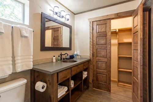a bathroom with a sink and a mirror at Two-Bedroom Cabin Rental with Fully Equipped Kitchen near Fredericksburg, Texas in Quinlan