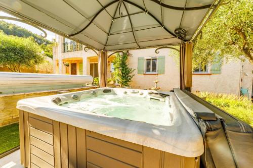 a hot tub in a backyard with an umbrella at Apartment with pool and garden in Taradeau