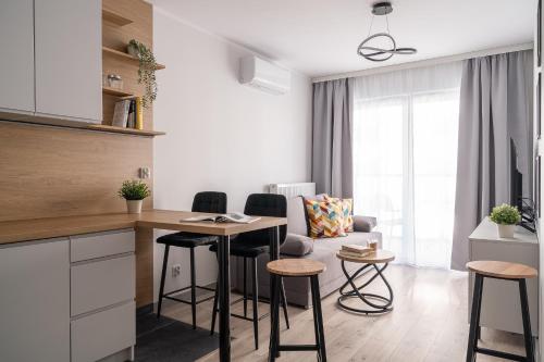 a kitchen and living room with a table and chairs at Symphony City Square Aparthotel in Wrocław