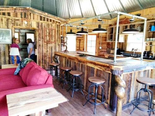 un bar avec un canapé rose dans une pièce dans l'établissement Rustic Octagon-Shaped Cabin for a Glamping Getaway near Huntington, West Virginia, à Genoa