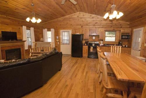 a living room with a couch and a table in a cabin at Charming Log Cabin with a Fire Pit in the Woods near Lake Logan in Ohio in Cedar Grove