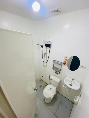 a bathroom with a toilet and a sink at BossBabe Nacpan Beach House in El Nido