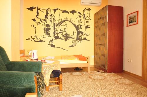 Cette chambre comprend un lit, une table et un mur. dans l'établissement Guest House Mirza, à Mostar