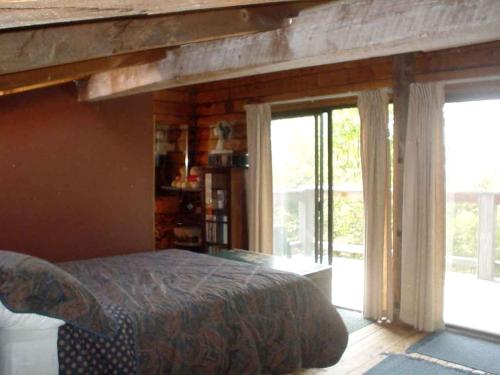 Schlafzimmer mit einem Bett und Glasschiebetüren in der Unterkunft Spacious 14-Person Cabin Perfect for Families in Mount Holly, Vermont in Hortonville