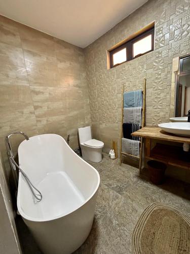 a bathroom with a tub and a toilet and a sink at Villa Ellapen in Pereybere