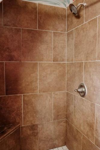 a bathroom with a shower with brown tile at Experience the Magic of Our Original Family Cabin in Tracy City, TN in Tracy City