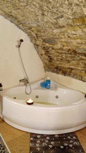 a bath tub in a bathroom with a stone wall at Il Borgo del Ghiro in Irola