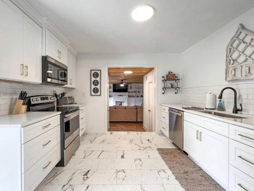 une cuisine avec des placards blancs et des appareils de cuisine dans l'établissement Great Cabin Perfect for Small Groups in Northport, Alabama, à Northport