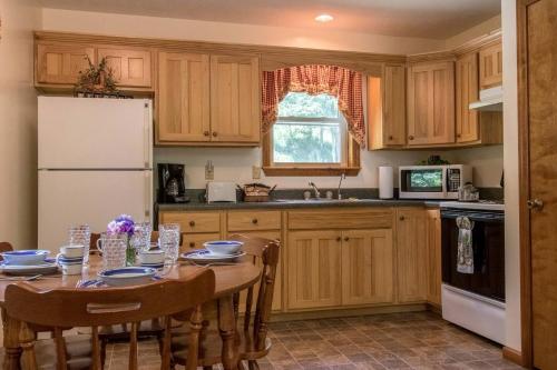 Una cocina con una mesa y un refrigerador blanco. en Secluded West Virginia Cabin Rental on the Edge of Monongahela National Forest, en Riverton