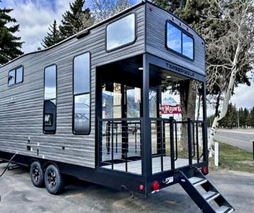 a tiny house is sitting on a trailer at Modern Lofted Tiny House Fully Equipped with Lake Views in Texas in Gilbreth