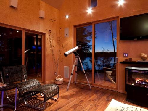 a camera in a room with a telescope at Unique Cottage Rental with Sublime Views Nestled on Damariscotta Lake in Maine in Jefferson