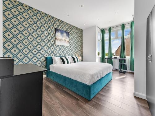 ein Schlafzimmer mit einem Bett und einer Wand in der Unterkunft Brand New Luxurious 3bed House in Northfleet