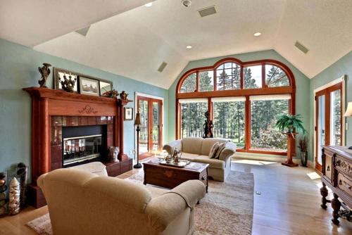 a living room with two couches and a fireplace at Four-Bedroom Luxury Vacation Rental on 80 Private Acres near Granite Peak, Wisconsin in Nutterville
