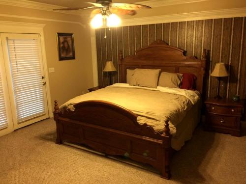 a bedroom with a large bed and a ceiling fan at Peaceful and Secluded Lake Getaway in Guntersville, Alabama in Albertville