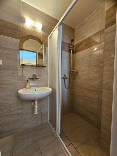 a bathroom with a sink and a shower at Penzion Zlata studna in Hlinsko
