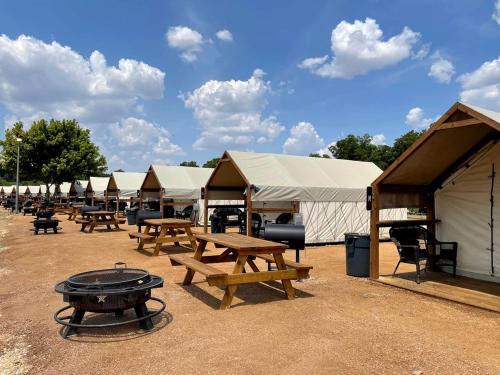 eine Reihe von Zelten mit Picknicktischen und einem Grill in der Unterkunft Amazing Aquatic Adventure for the Whole Family: Luxurious Safari Tent near Kingsbury, Texas in Marion