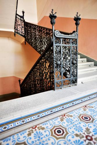 a staircase with an ornate metal railing and a tile floor at Broadway Residence in Budapest