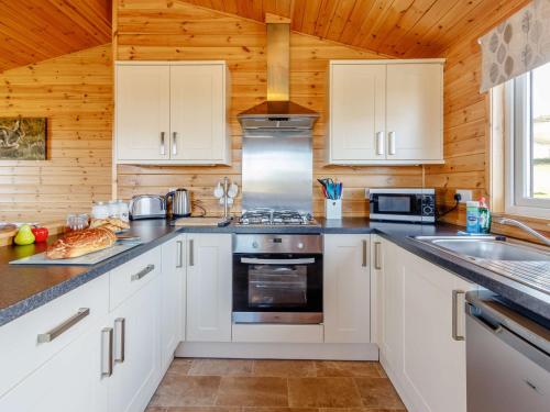 a kitchen with white cabinets and a stove top oven at 2 Bed in Loch Leven 82297 in Kinross