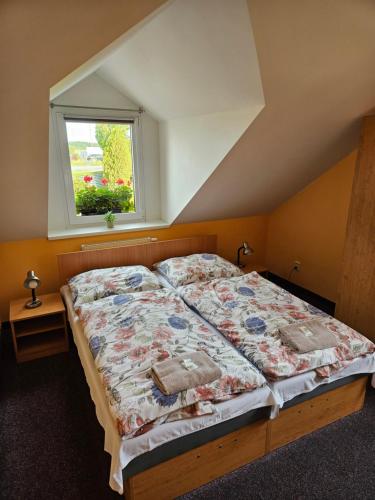 a bed in a bedroom with a window at Penzion Zlata studna in Hlinsko