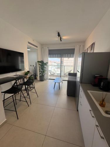 a kitchen and dining room with a table and chairs at פסגת הדקל- דירה מודרנית עם נוף להרים in Eilat