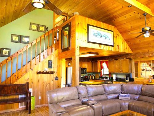 a living room with a leather couch in a cabin at Luxury Cabin Rental for a Family Getaway in Pigeon Forge, Tennessee in Waldens Creek