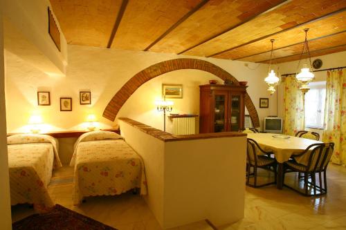 sypialnia z 2 łóżkami i stołem w pokoju w obiekcie Casa Terra Rossa w mieście Fauglia