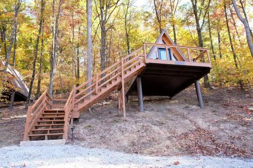een boomhut met een trap in het bos bij Romantic A-frame Cabin Ideal for Two by Tappan Lake in Ohio 