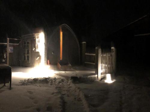 a barn lit up in the snow at night at Ferienhaus Zillendorf in Zillendorf