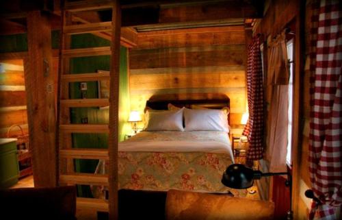 ein Schlafzimmer mit einem Bett mit einer Holzwand in der Unterkunft Beautiful Waterfront Cabin with Hot Tub near Winston-Salem, North Carolina in Elkin