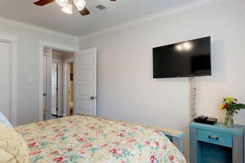 a bedroom with a bed and a flat screen tv on the wall at Modern Farmhouse Escape with Patio & Fire Pit in Bryan, Texas in Bryan