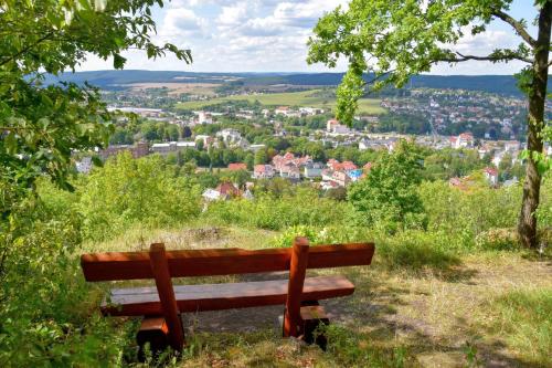 a bench sitting on top of a hill with a city at Pößnecker Werkstätten - Alte Bäckerei in Pößneck