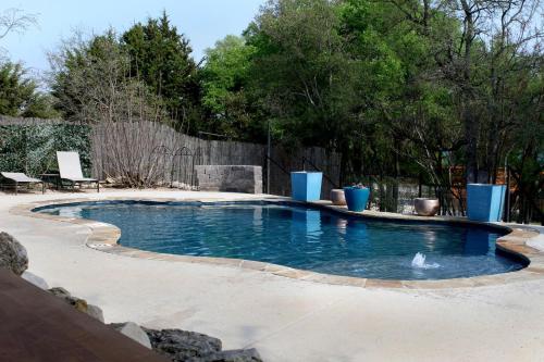 a swimming pool in a backyard with a fence at Perfect Texas Glamping in this Cozy Log Cabin Rental for 4 near Austin in Pipe Creek